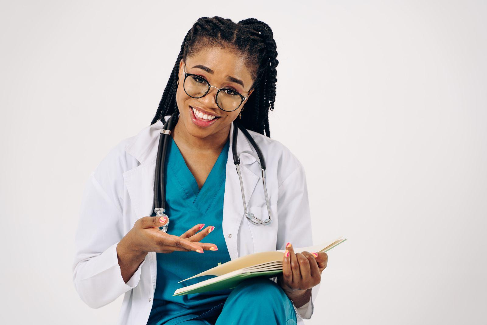 Médica sorridente conversando com o paciente com o prontuário na mão